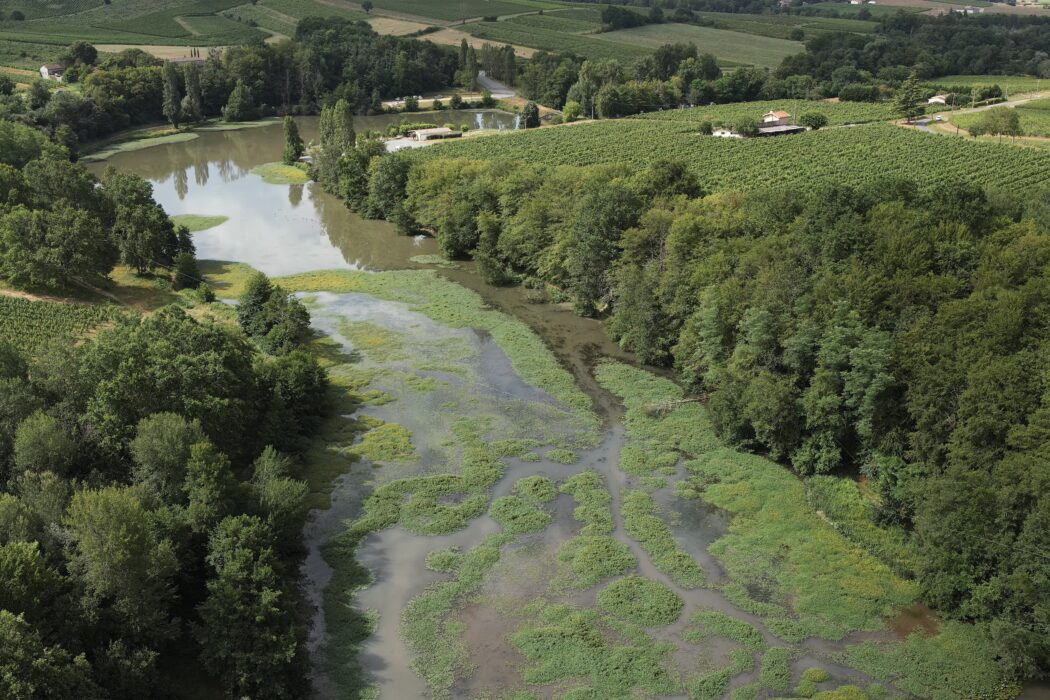Photo vue du ciel du site de Laromet dans son état actuel. Une grande zone de marais en amont avec de nombreux herbiers composée de jussie qui est une plante exotique envahissante. On aperçois également au second plan de le restaurant et une partie du barrage